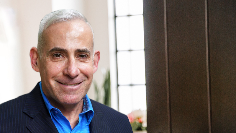 Headshot of Joshua Lesser wearing a blue shirt and navy blazer