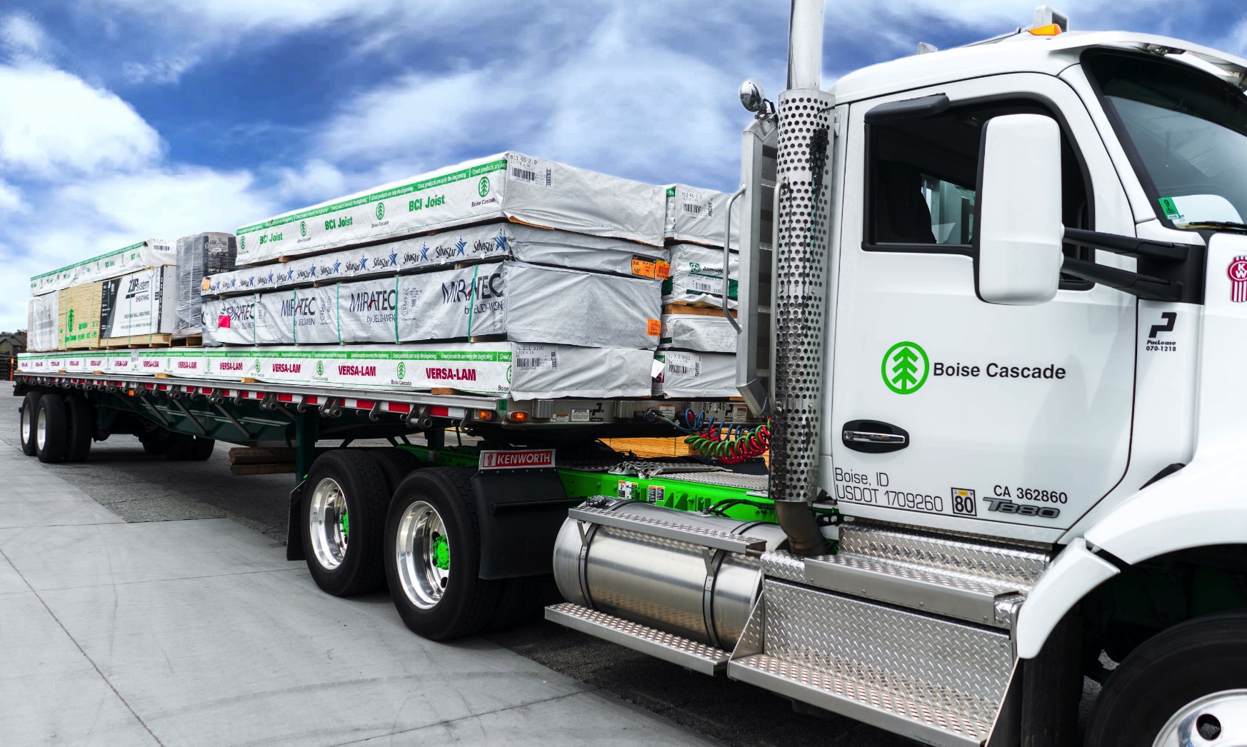 White Boise Cascade semi truck with stacked wrapped lumber on a flatbed trailer