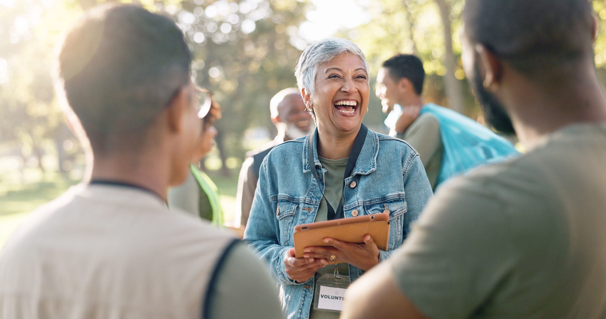 Woman holding clipboard talking to others while outside